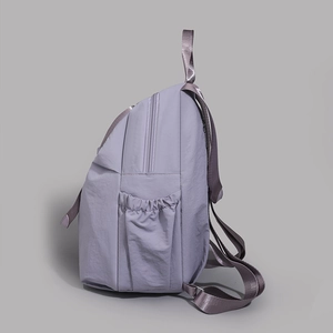 Side view of lavender water-resistant nylon backpack with elastic side pocket detail
