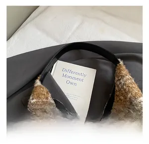Détail du tissu en laine à carreaux marron avec poignée en cuir noir sur cabas d'automne