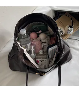 Vue de dessus de l'intérieur spacieux du sac fourre-tout marron avec des objets du quotidien