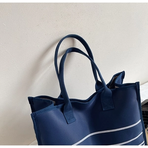 Detail of navy blue striped canvas tote bag showing durable handles and fabric texture
