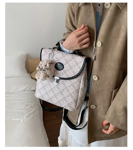 Detail of checkered casual backpack with plush bunny charm and round brand logo metal plate