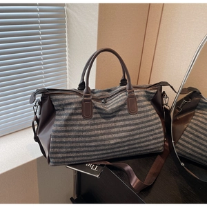 Detail of blue striped sports gym bag with leather handles and adjustable shoulder strap
