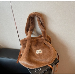 Détail du sac fourre-tout en peluche caramel avec plaque en perles et bandoulière