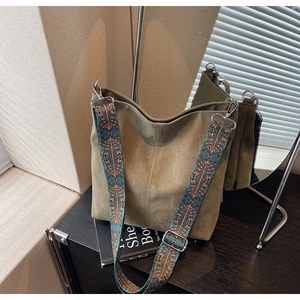 Detailed mirror view of olive green canvas hobo bag with ethnic embroidery shoulder strap