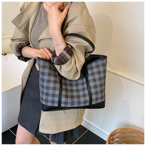 Detail shot of the spacious checked tote bag in grey and black faux leather on shoulder
