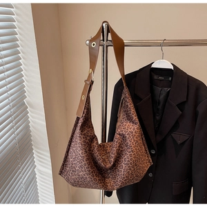 Détail du sac hobo léopard avec bandoulière réglable en cuir marron et œillets en métal