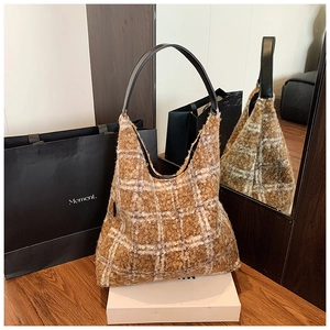 Détail du grand sac cabas en laine à carreaux marron avec texture pelucheuse et cuir noir