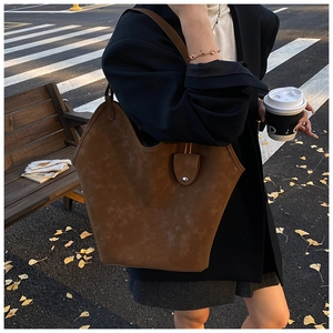 Brown suede leather tote bag shown in a stylish autumn street scene setting