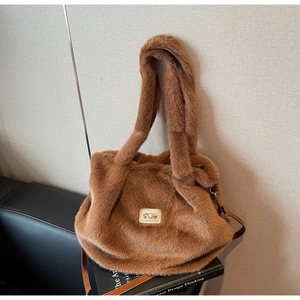 Détail d'un sac cabas en fausse fourrure marron avec logo orné de perles élégantes