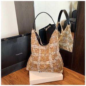 Détail du sac cabas en polaire à carreaux avec bandoulière en cuir noir et texture douce