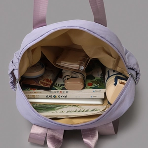 Spacious interior of a purple tote bag showing laptop compartment and large storage capacity