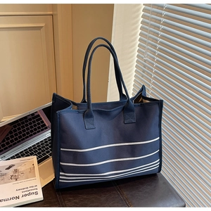 Detail of navy blue striped canvas tote bag showing wide base and large capacity storage