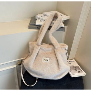 Détail d'un sac cabas en fausse fourrure crème avec poignées larges et bandoulière amovible