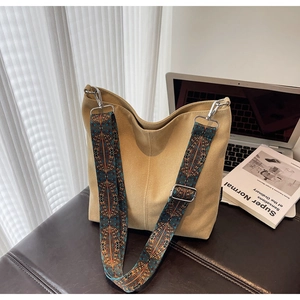 Detail of khaki canvas bucket bag with adjustable ethnic style jacquard shoulder strap