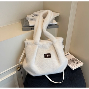 Détail du sac cabas en fausse fourrure blanche avec texture pelucheuse et patch en cuir