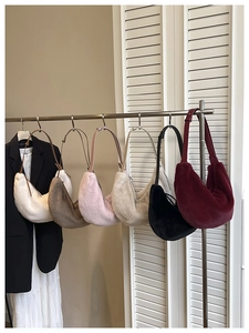 Plush faux fur crescent bags in six trendy colors hanging on a display rack in a boutique
