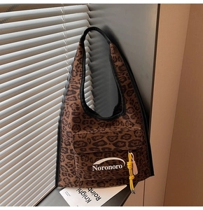 Detail of leopard print suede shoulder bag featuring a front pocket and decorative knot