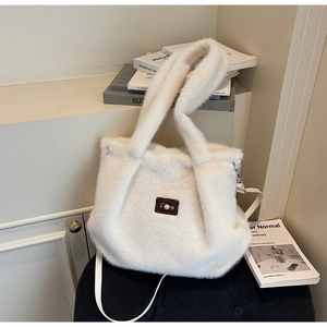 Vue détaillée du sac cabas en peluche blanche avec étiquette perle et bandoulière