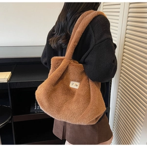 Détail du sac cabas en fausse fourrure marron montrant la texture et l'écusson blanc