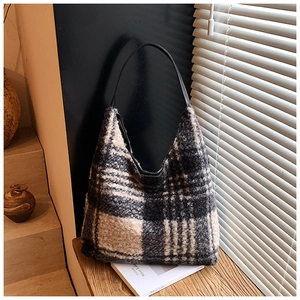 Vue détaillée du sac cabas en laine à carreaux avec texture douce et sangle en cuir