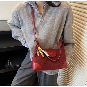 Detail of burgundy patchwork dumpling bag with beads and adjustable shoulder strap