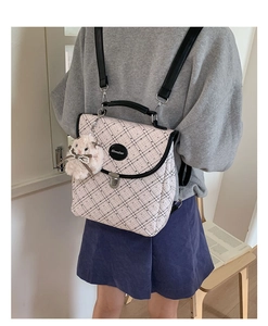 Detail of checkered backpack with pink rabbit plush charm and metal buckle closure