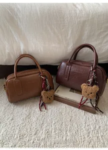 Dettaglio di borse Boston vintage in pelle cerata con accessori ciondolo orsetto