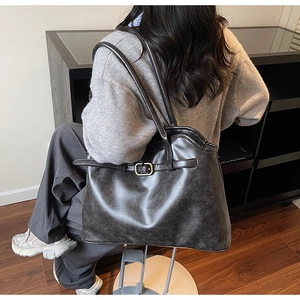 Gros plan du grand sac cabas vintage en cuir noir avec boucle métallique décorative