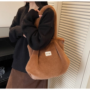 Gros plan d'un sac cabas marron en fausse fourrure douce avec une étiquette brodée