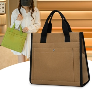 Detail of canvas tote bag with metal snap button and contrast black handles