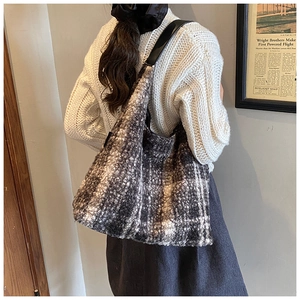 Vue détaillée d'un grand sac cabas en tweed à carreaux porté à l'épaule pour l'automne