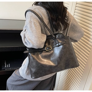 Grand sac cabas noir avec texture en cuir rétro et boucle dorée élégante en gros plan
