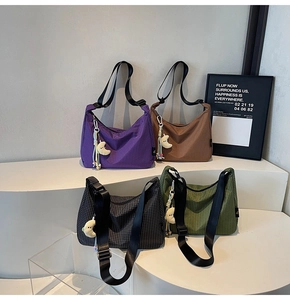 Détail de sacs hobo à carreaux multicolores avec breloques lune en peluche sur support