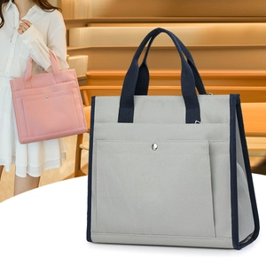 Detail view of large canvas tote bag with multi-pocket design and metal buckle closure