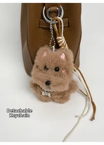 Detail of plush dog charm with pearl collar and metal tag on a brown bucket bag
