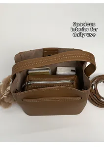Interior view of brown lychee grain bucket bag showing capacity and zipper compartment
