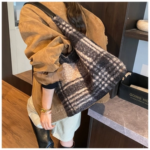 Détail de la texture d'un sac à bandoulière en laine à carreaux noirs et blancs