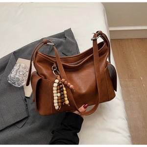 Detailed close-up of brown vintage PU leather bucket bag with wooden bead charm
