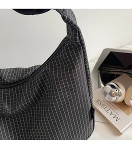 Détail du sac à main en toile à carreaux noirs et blancs avec ordinateur portable