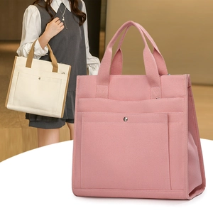 Close-up of canvas tote bag with front snap pocket showing pink and cream color options