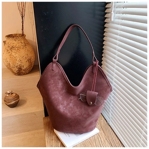 Macro view of vintage burgundy suede shoulder bag with matching glasses holder pouch