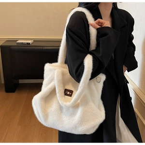 Détail du grand sac cabas en fausse fourrure blanche avec écusson en cuir et perles