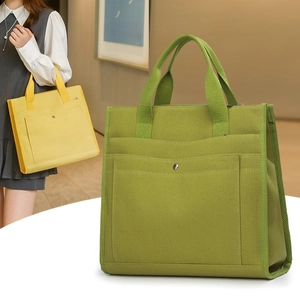 Detail of canvas tote bag with functional pockets and metal snap button closure