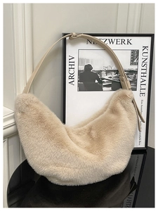 Detail of beige faux fur hobo bag with soft plush texture and wide leather shoulder strap
