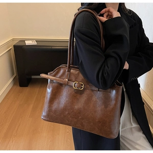Gros plan sur un cabas vintage marron avec boucle en métal doré et finition similicuir
