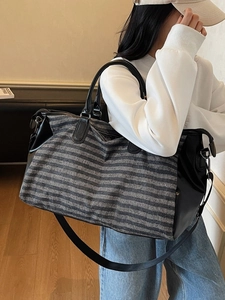 Black and grey striped sports travel bag with leather accents and shoe compartment