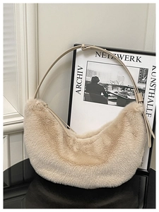Detail of soft beige faux fur texture on half-moon bag with adjustable shoulder strap