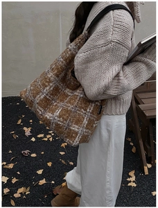 Vue détaillée du sac cabas en laine à carreaux marron avec texture pelucheuse et bandoulière noire