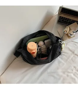 Vue détaillée de l'intérieur spacieux du sac à carreaux montrant un thermos et un parapluie