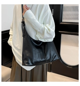Detail view of large black retro hobo bag with textured leather and adjustable gold buckle